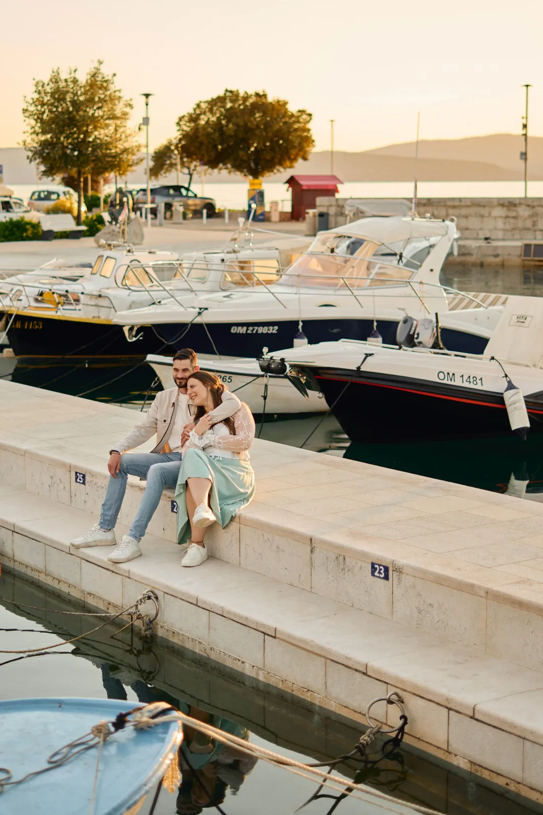 Newly engaged couple sitting together on the harbour front in Zadar