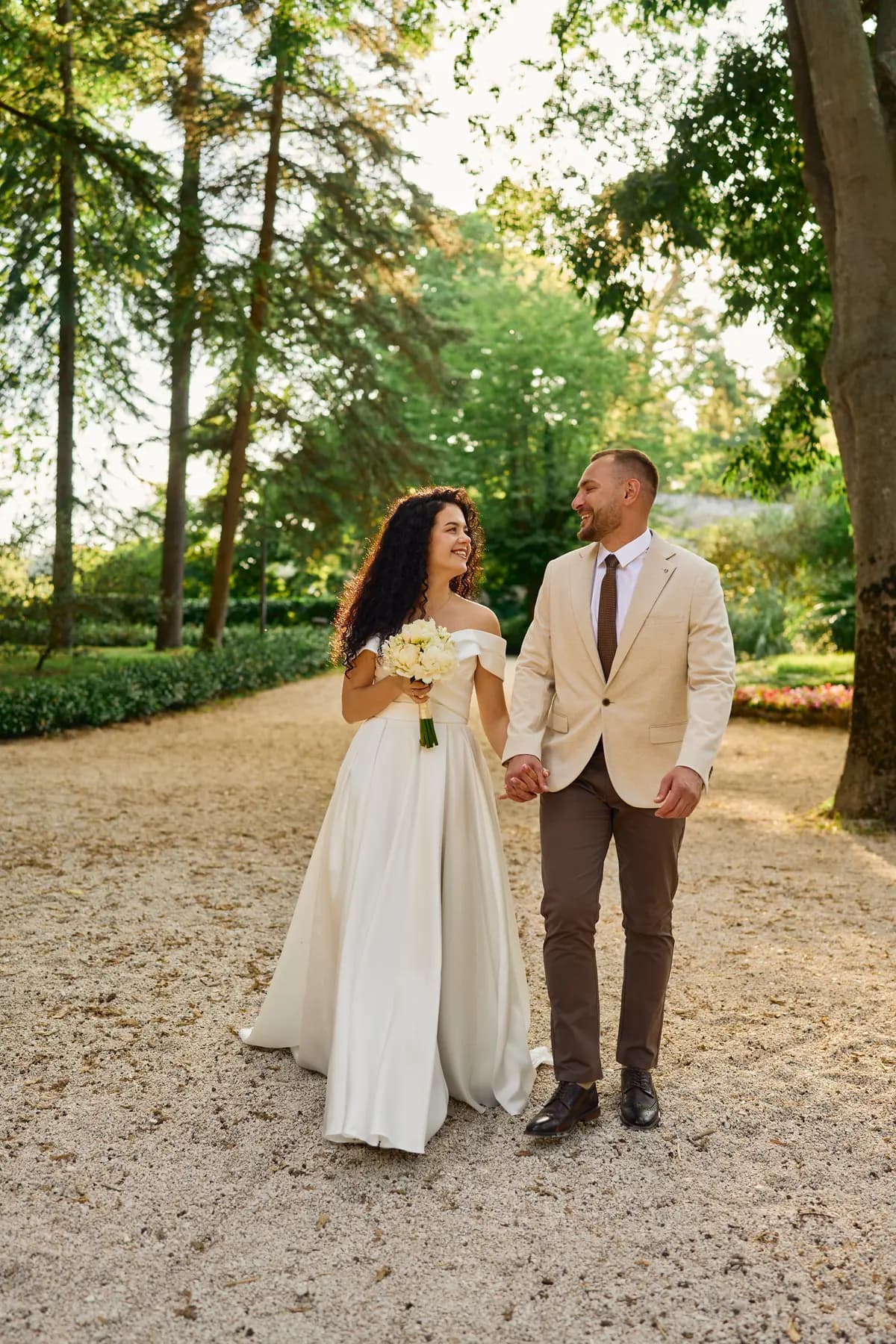 Bride and groom walking together through a pine park