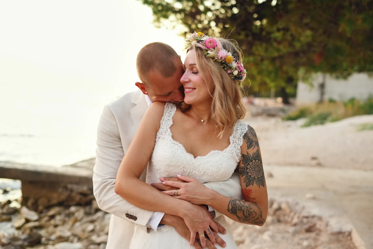 Groom holding his bride close, a flower crown in her hair