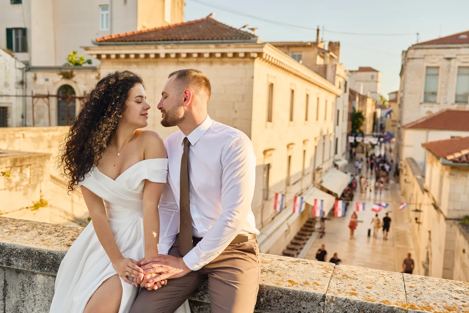 Couple sitting on a wall above an old town street