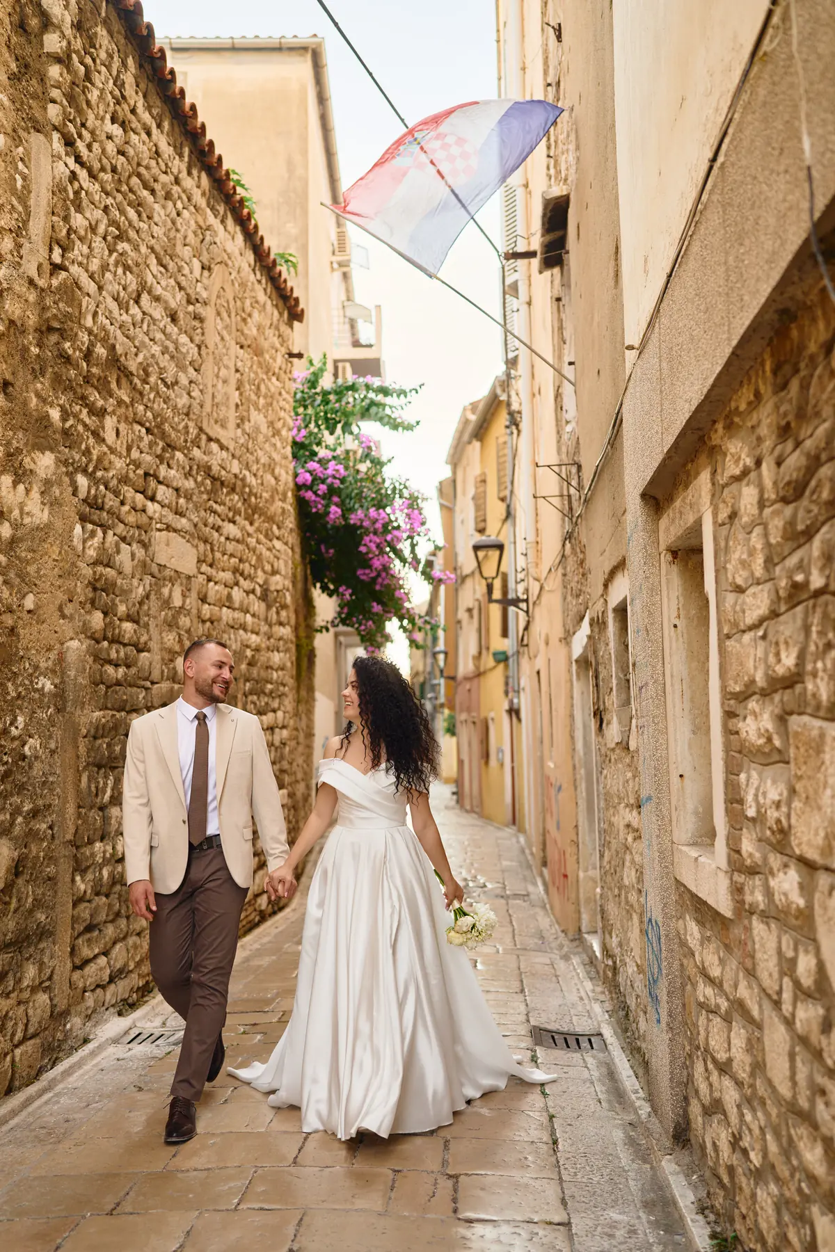 Couple walking hand in hand through a narrow old town street