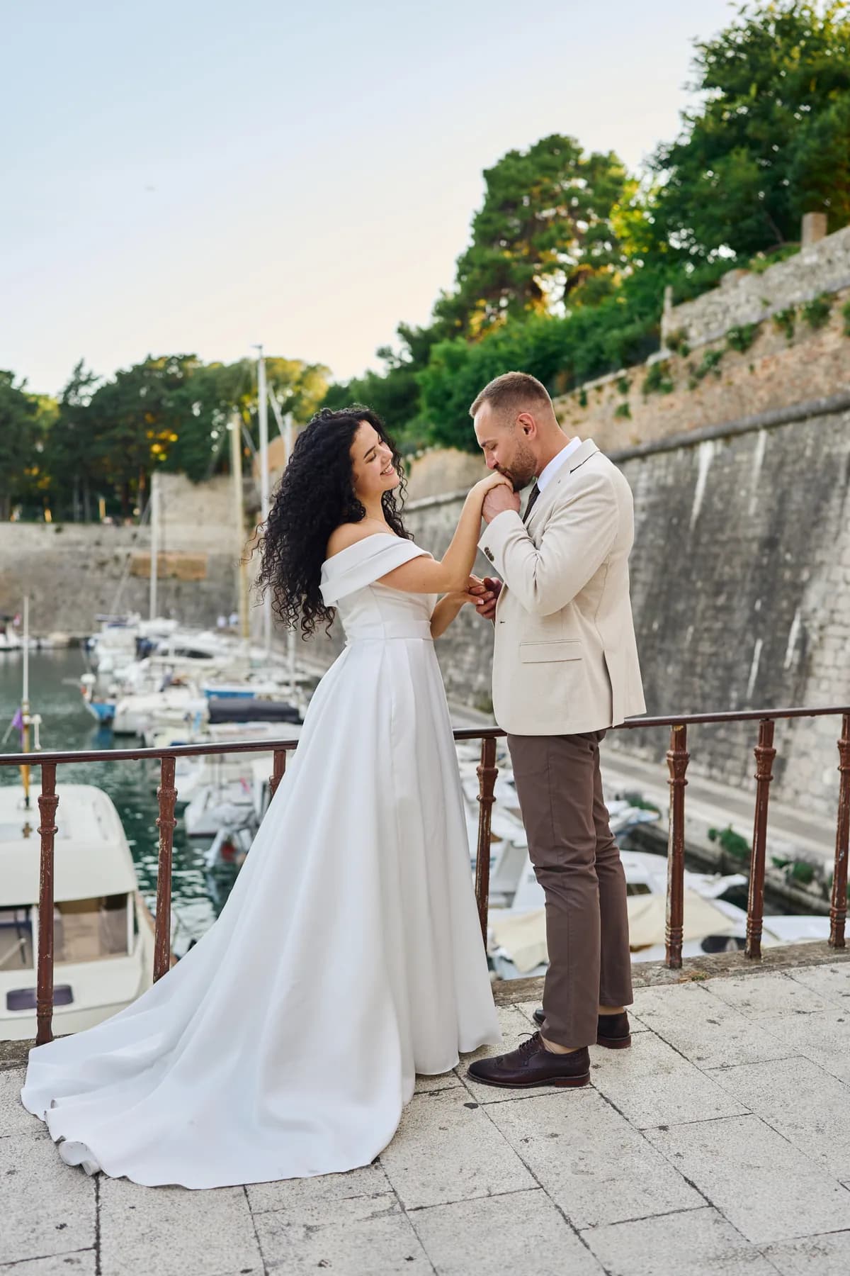 Bride and groom by the marina below the old city walls