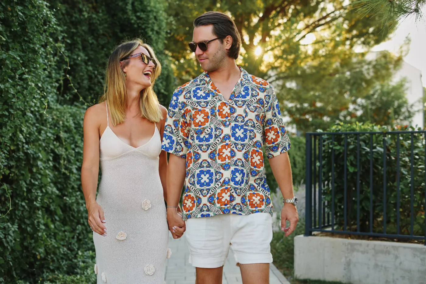 A couple holding hands and laughing as they look at each other during their Zadar photo session