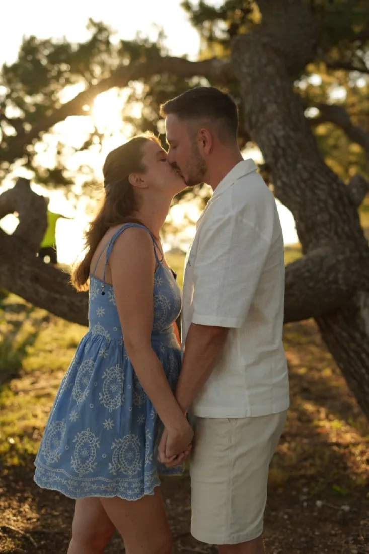 A couple in coordinated but different colours — a blue dress and cream linen — at golden hour in Zadar